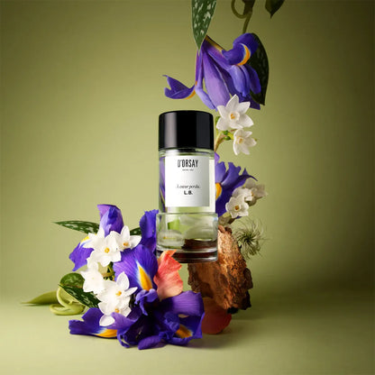 Bottle of Désiré perfume with flowers on a green background