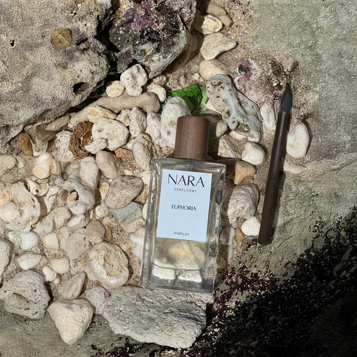 NARA perfume bottle on a rocky surface