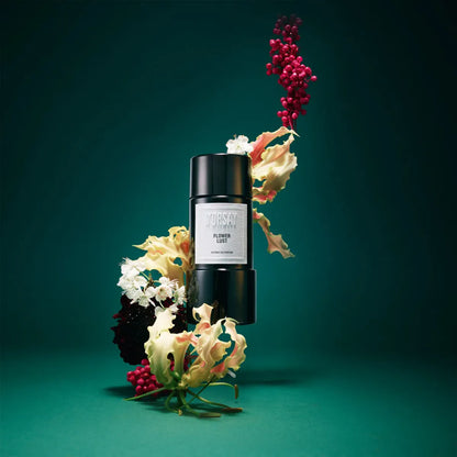 Black cylindrical product with a label on a teal background with floral elements