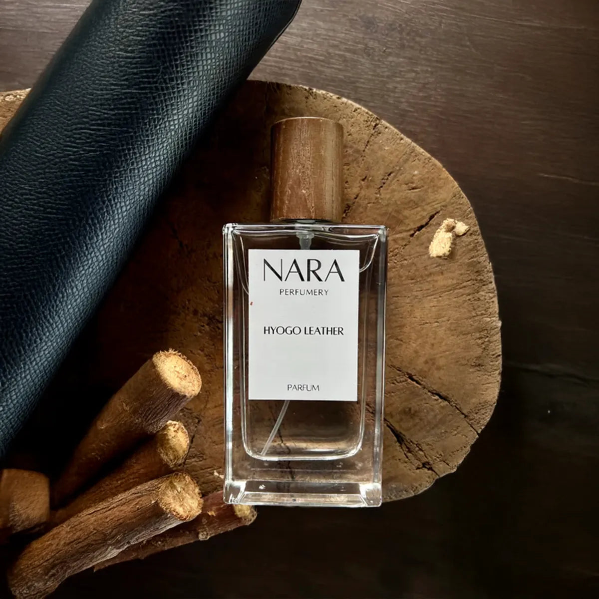 NARA Parfum bottle on a wooden surface with leather and wood elements
