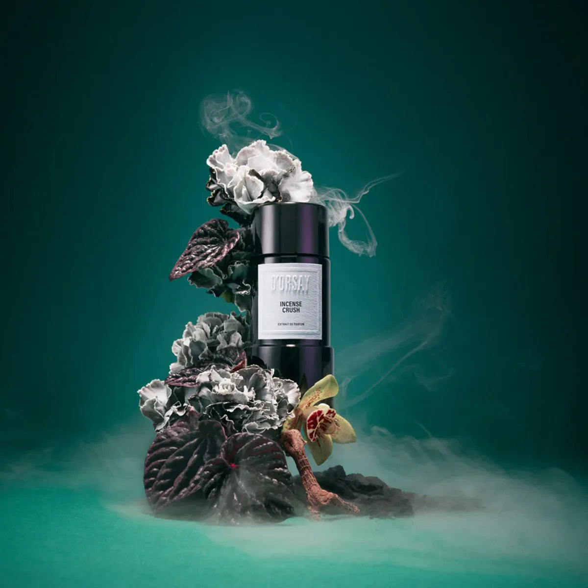 Black cylindrical product with white label on a decorative stand with flowers and leaves against a teal background