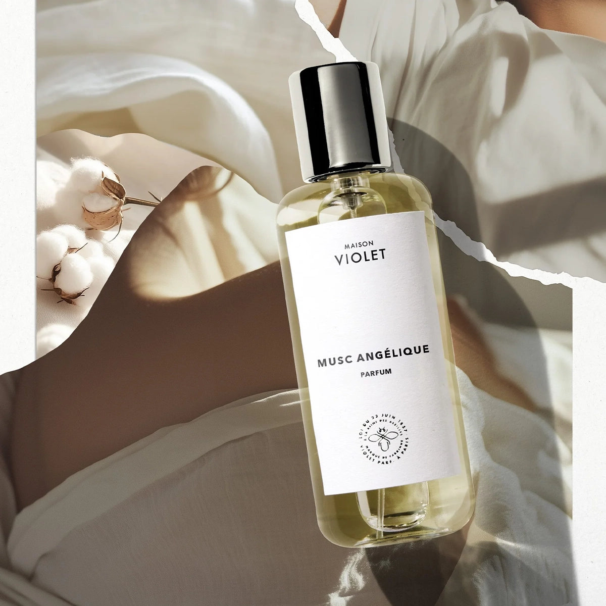 Musc Angélique by Maison Violet perfume bottle styled with cotton and white blossoms on bright background
