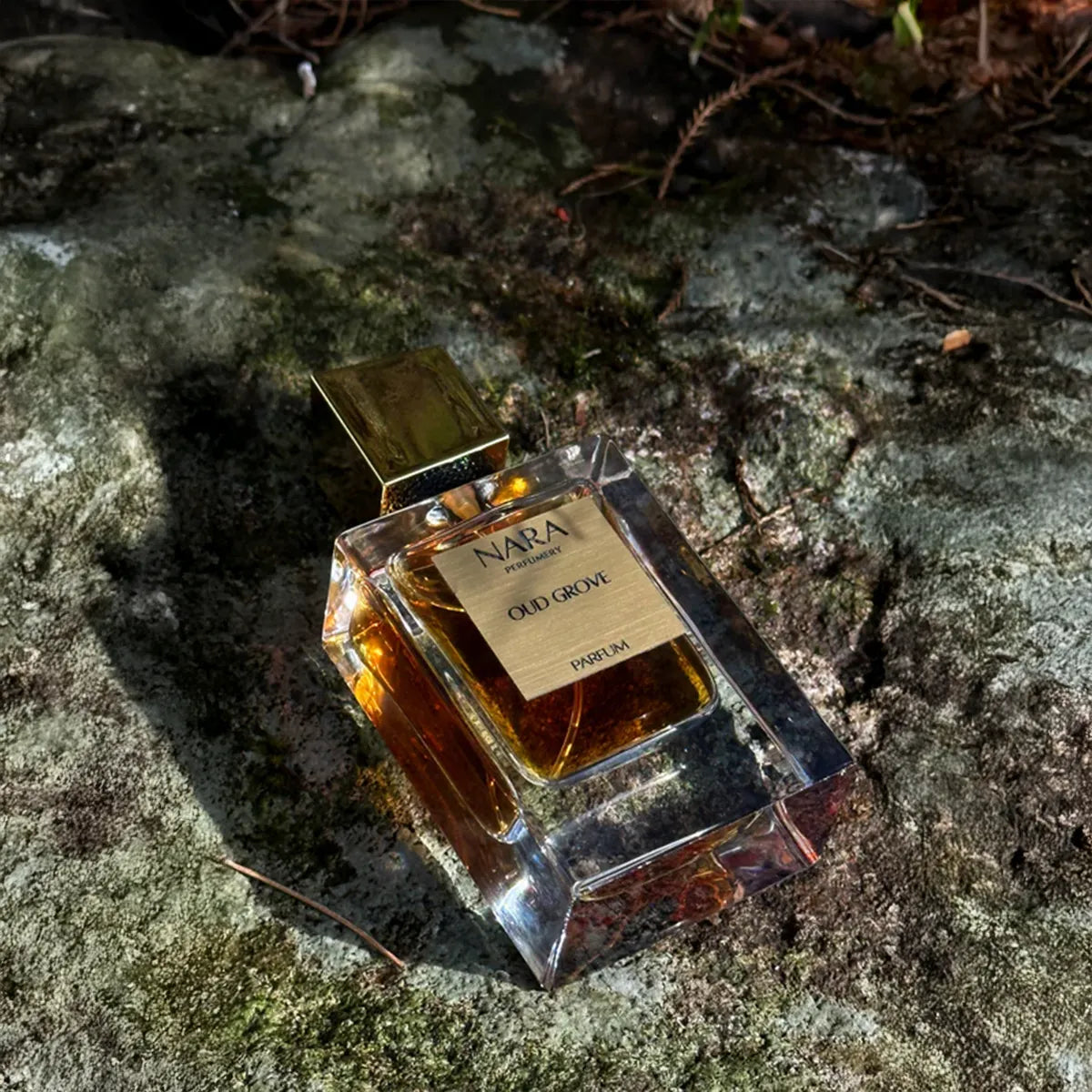 Perfume bottle labeled 'Nara' on a textured stone surface