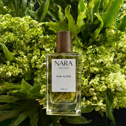 NARA Perfumery Rain Water perfume bottle surrounded by green foliage