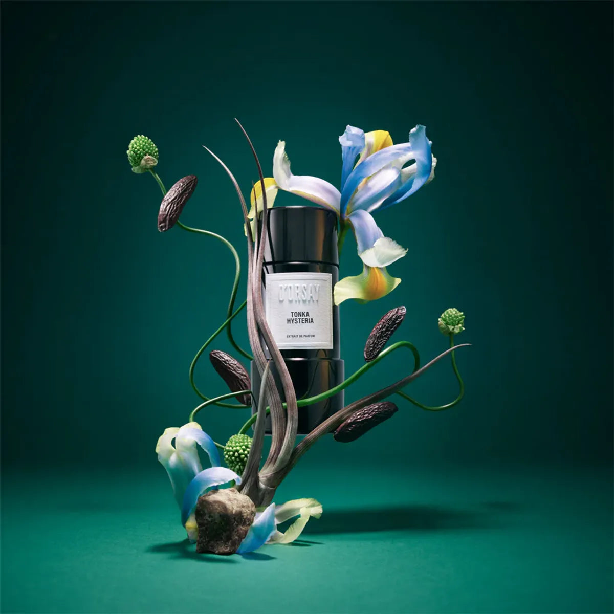Bottle of tonka bean extract surrounded by flowers and plants on a green background